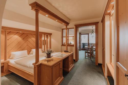 a bedroom with a canopy bed and a table at Weßner Hof Landhotel & Restaurant in Marquartstein