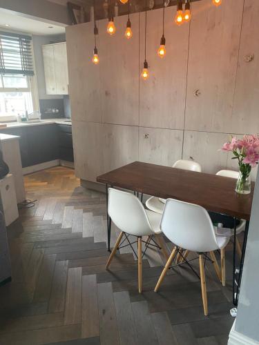 een eetkamer met een houten tafel en witte stoelen bij Luxury 2 bedroom flat heart of Camden in Londen