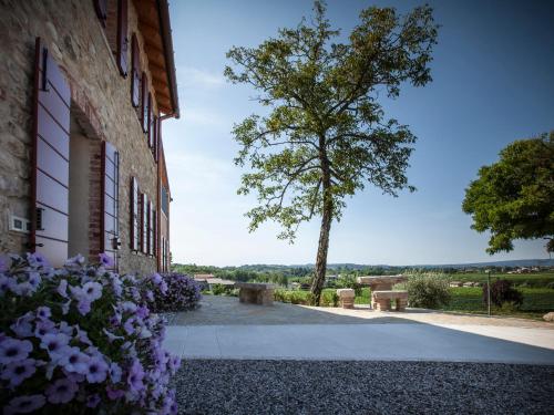 a building with flowers next to a tree at Le Pervinche in Refrontolo