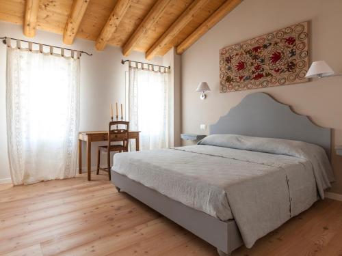 a bedroom with a large bed and a table at Le Pervinche in Refrontolo