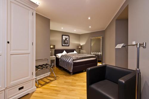 a bedroom with a bed and a chair at Hotel Wagner im Dammtorpalais in Hamburg