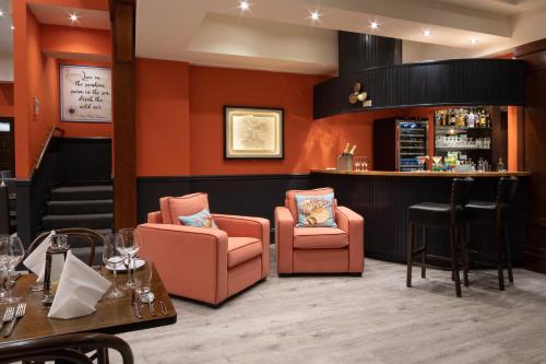 a restaurant with orange walls and chairs and a bar at The Mariner, Westport in Westport