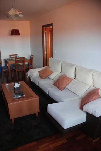 米尼奧的住宿－Piso céntrico en Miño.，客厅配有2张白色沙发和1张桌子