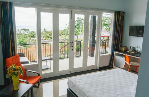 a bedroom with a balcony with a bed and a window at House of Belasun in Pelabuhan Ratu