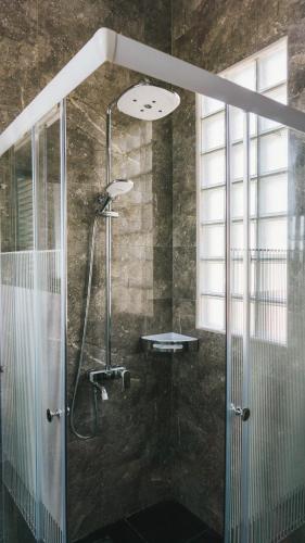 a shower with a glass door in a bathroom at House of Belasun in Pelabuhan Ratu