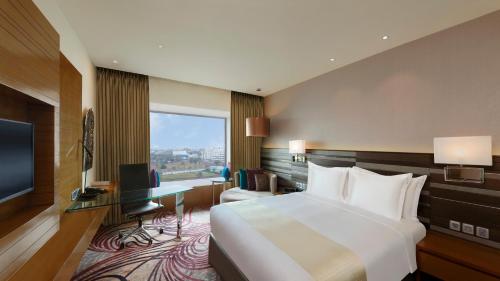 a hotel room with a bed and a desk and a television at Holiday Inn Jaipur City Centre, an IHG Hotel in Jaipur