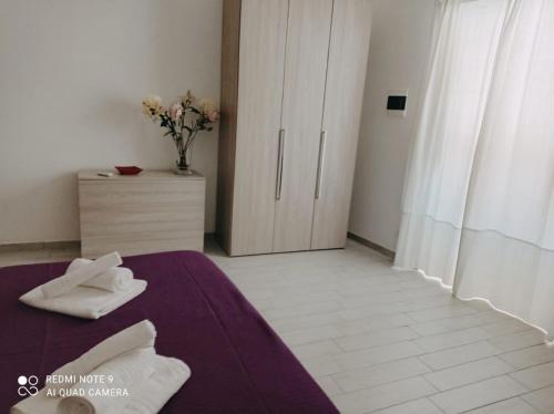 a bedroom with a bed with two white towels on it at La Casa di Katia in Canicattì