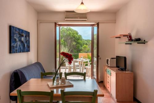 a dining room with a table and a television at Residence Le Pavoncelle in Santa Teresa Gallura