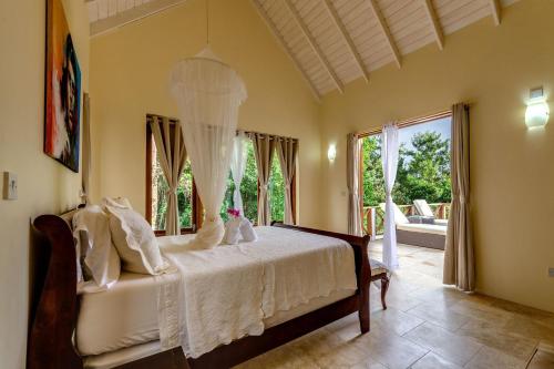 a bedroom with a bed and a large window at Sadewa Villa in Port Elizabeth