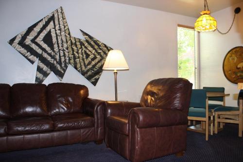 a living room with a leather couch and a table at St Moritz Lodge and Condominiums in Aspen