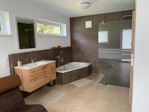 a bathroom with a tub and a sink and a shower at Ferienhaus Feil in Oberdrauburg