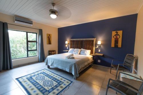 a bedroom with a bed and a blue wall at Asuite-Dream in Hoedspruit