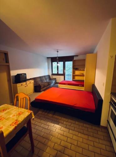 1 dormitorio con cama, sofá y mesa en Gemmi apartment Inden Leukerbad en Inden