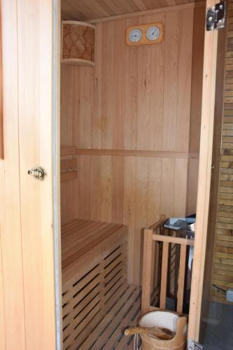 a small sauna with a wooden paneled wall with a wooden bench at Les Portes Du Hable in Cayeux-sur-Mer