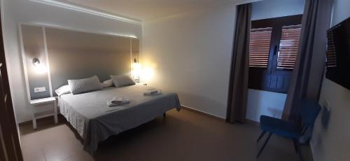 Dormitorio pequeño con cama y espejo en Apartamento Paz, en Playa Blanca