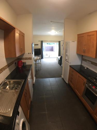eine Küche mit Holzschränken und einer Arbeitsplatte in der Unterkunft 4 Bedrooms, 3 Bathrooms, Comfy beds, 5 Netflix TVs & VAN PARKING in Boston