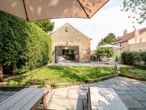 a garden with a patio and a house at The Coach House in Sleaford
