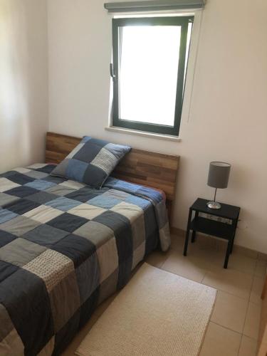 Schlafzimmer mit einem Bett und einem Fenster in der Unterkunft Victory Village Apartamento in Quinta do Lago
