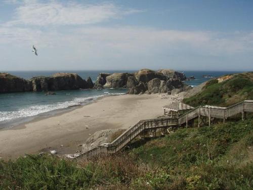 a sandy beach with stairs leading to the ocean at Summer Wind Budget Motel in Newport