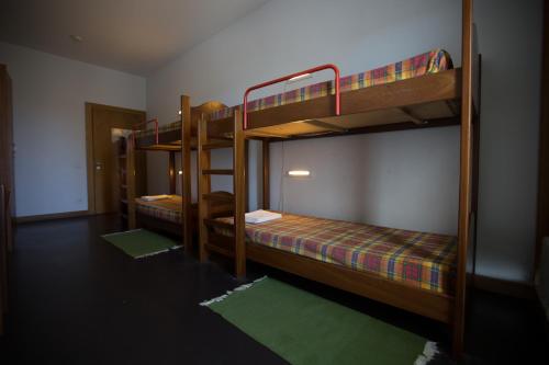 2 Etagenbetten in einem Zimmer mit grünem Teppich in der Unterkunft HI Viana do Castelo - Pousada de Juventude in Viana do Castelo