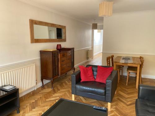 ein Wohnzimmer mit einem Stuhl und einem Tisch in der Unterkunft Byways Serviced Apartments in Salisbury