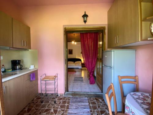 a kitchen with a refrigerator and a room with a bedroom at Kallisto Guesthouse in Tsagarada