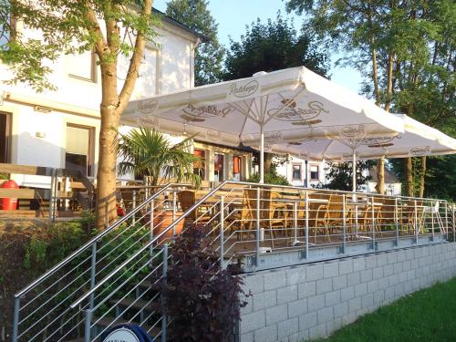 a restaurant with tables and chairs under an umbrella at Landgasthof Zur Post, Hochwälder Radstation in Kell