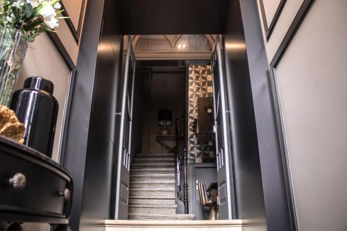 a hallway with a staircase with black walls at 34 GuestHouse in Setúbal