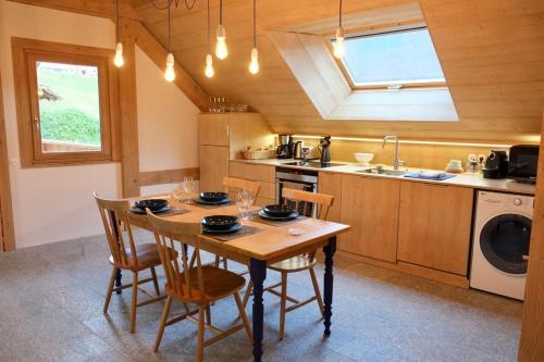 - une cuisine avec une table, des chaises et un évier dans l'établissement L'Alpage de la Bergerie apartment in a cosy farmhouse !, à Nâves-Parmelan
