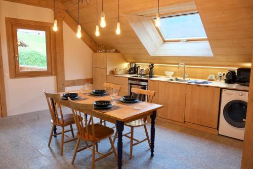 una cucina con tavolo, sedie e lavandino di L'Alpage de la Bergerie apartment in a cosy farmhouse ! a Nâves-Parmelan