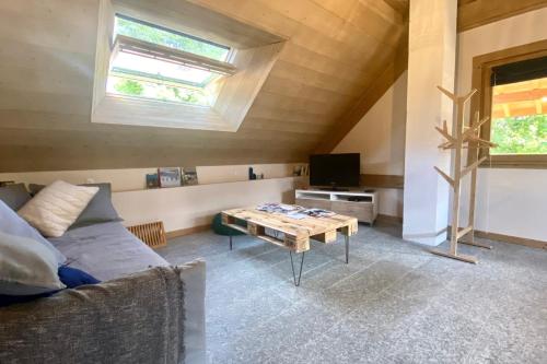 a living room with a couch and a table at L'Alpage de la Bergerie apartment in a cosy farmhouse ! in Nâves-Parmelan