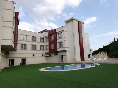 un bâtiment avec une pelouse verte devant un bâtiment dans l'établissement Tuna Hotel, à Muğla