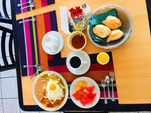 einen Tisch mit Frühstücksteller darauf in der Unterkunft Hotel Flamingo Irapuato in Irapuato