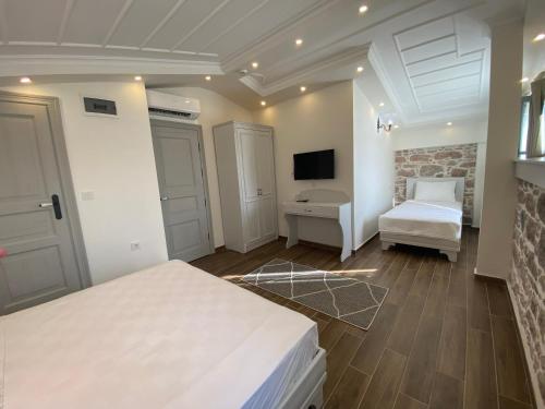 a bedroom with two beds and a television in it at Cunda Ömer Ağa Konağı in Cunda