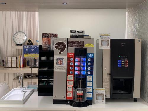 a coffee dispenser on a counter next to a sink at Ochanomizu Inn in Tokyo
