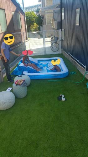 a group of people playing in a pool in a yard at Tiz wan 岩屋あわじ in Awaji