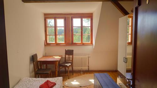 a room with a table and two chairs and a window at Farma Hermína in Jilemnice