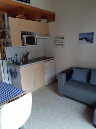- une petite cuisine avec un canapé et une table dans une chambre dans l'établissement Appartement Azalee, à Châtel