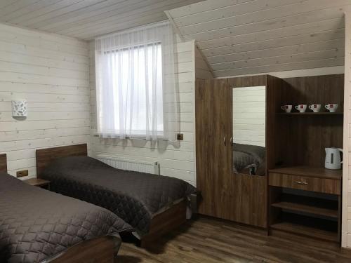a bedroom with two beds and a window at готель Вікторія in Volovets