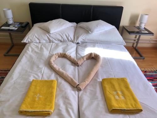 a bed with two towels in the shape of a heart at Hotel Oroszlán Szigetvár in Szigetvár