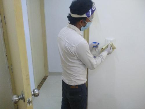 a man wearing a mask painting a wall at The Palm Tree -Family Stay in Amritsar