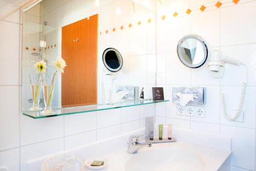 a bathroom with a sink and a mirror at Hotel Seeperle in Langenargen