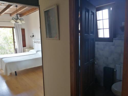 a room with a bed and a door to a bathroom at Posada El Jardin de Angela in Santander