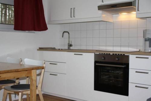 cocina con electrodomésticos blancos y mesa de madera en SeeLodge Jabel Appartment 2, en Jabel