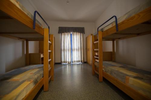 two bunk beds in a room with a window at HI Beja - Pousada de Juventude in Beja