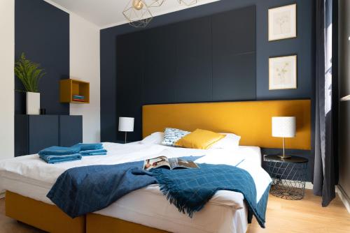 a bedroom with a large bed with a blue accent wall at LeoApart in Wrocław