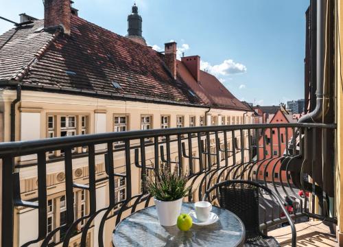 a table with a cup of coffee on a balcony at LeoApart in Wrocław