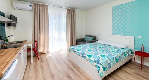 1 dormitorio pequeño con 1 cama y cocina en Апартаменты "Гамма ДеЛюкс", en Olginka