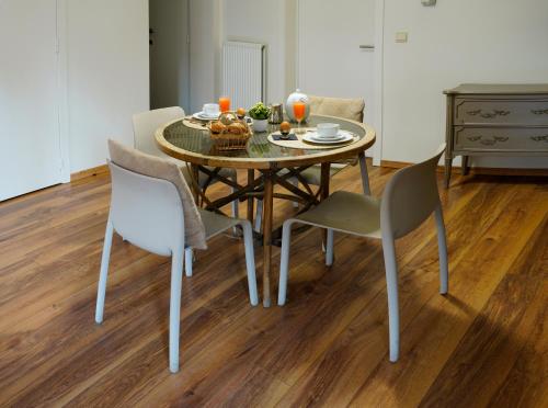 a dining room table and chairs with a bowl of fruit on it at Apartments Ypres in Ypres