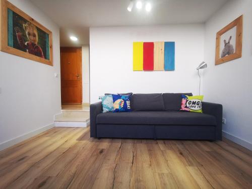 a living room with a blue couch and wooden floors at FABRIQ apartment in Alicante